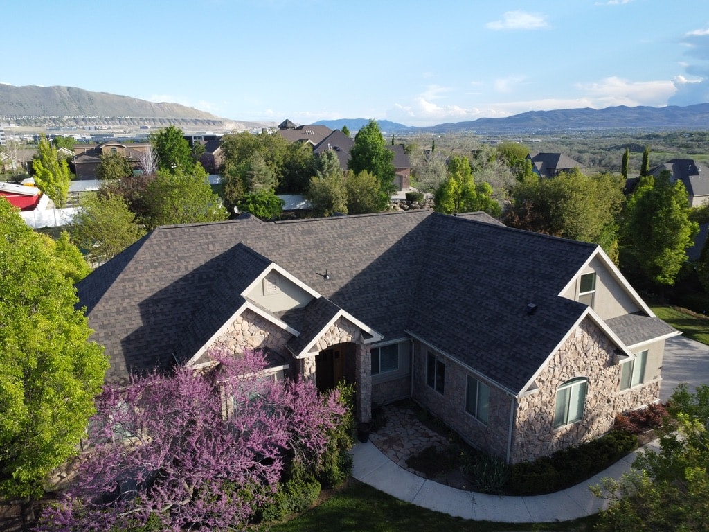 Completed roof on stone exterior home with Utah valley backdrop